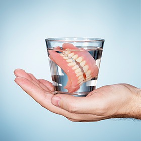 Full set of dentures in a glass of water