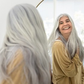 Dentures patient in Goode smiling in the mirror