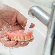 Dentures are rinsed in sink