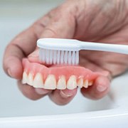 Dentures cleaned with brush