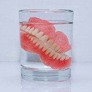 Dentures soak in glass of liquid